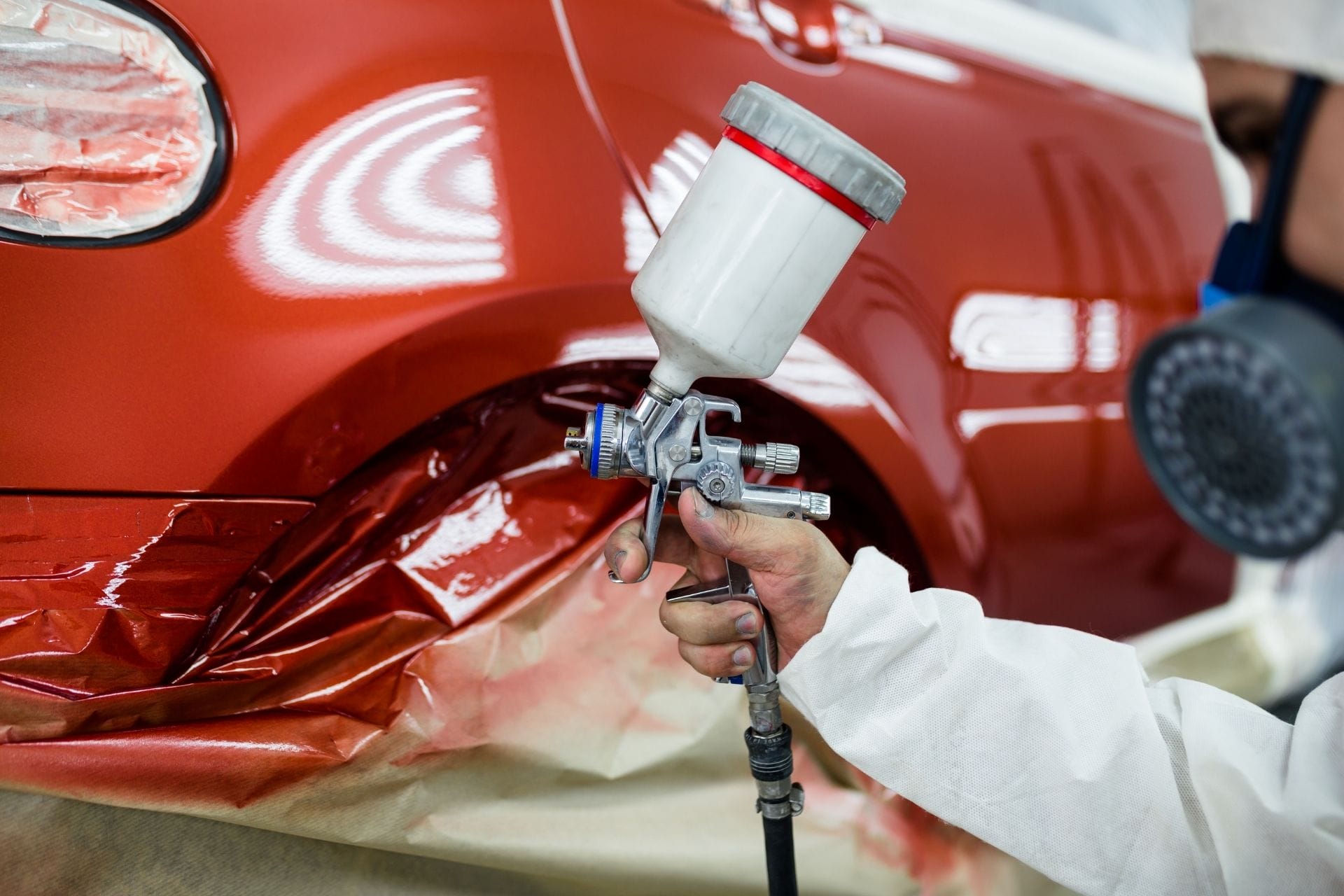 guy spraying car in red
