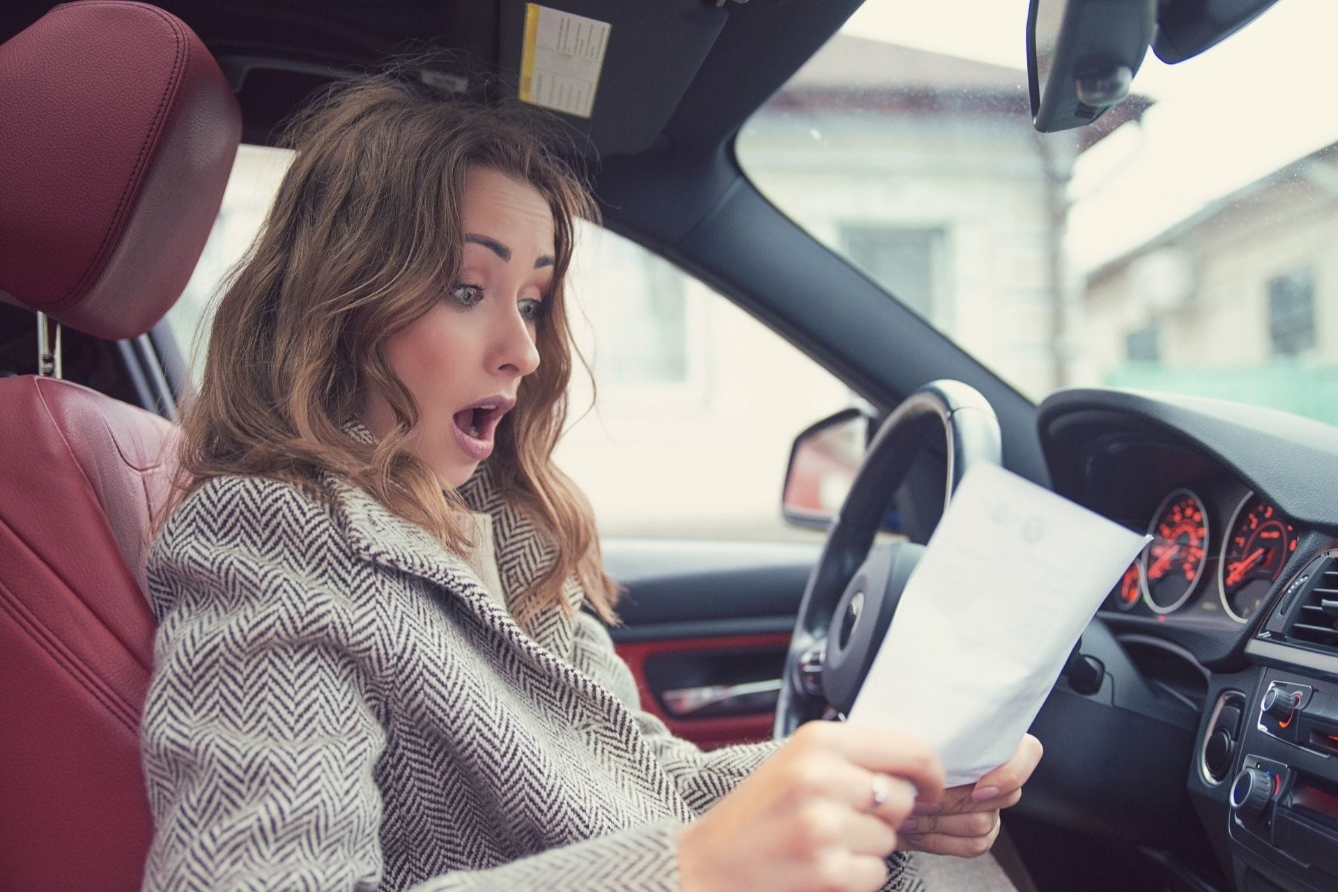 girl shocking holding a paper in car