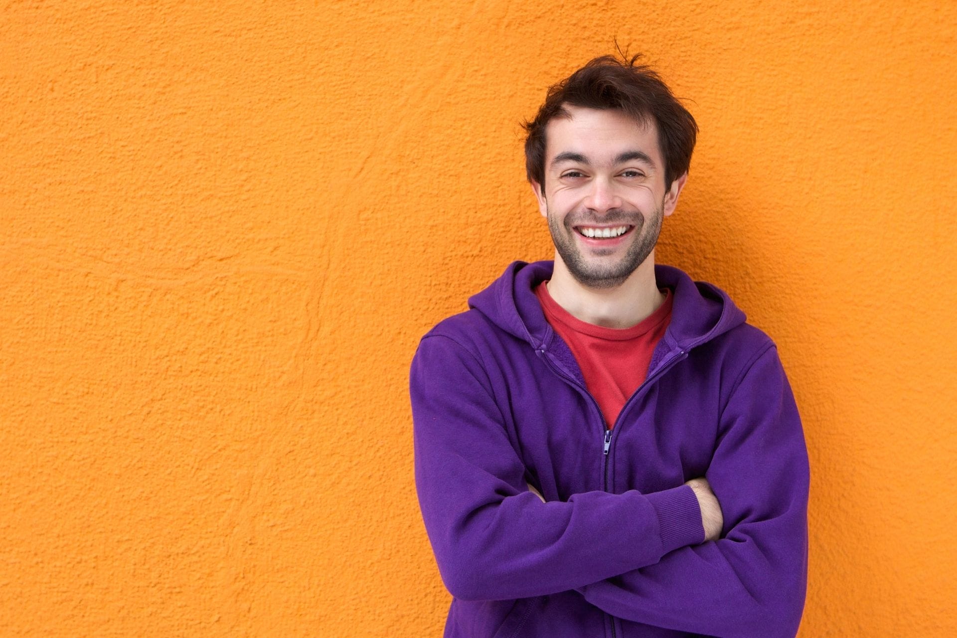 guy smiling wear purple hoodie-orange background